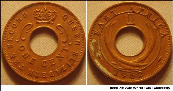 East Africa | 
1 Cent, 1962 | 
20 mm, 2 gr. | 
Bronze | 

Obverse: Crown above centre hole, denomination below | 
Lettering: QUEEN ELIZABETH THE SECOND ONE CENT | 

Reverse: Curved tusks, denomination above and date below | 
Lettering: EAST AFRICA 1 1962 |