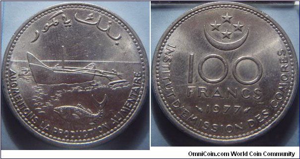 Comoro Islands | 
100 Francs, 1977 - FAO | 
28.5 mm, 10 gr. | 
Nickel | 

Obverse: Outrigger and a fish | 
Lettering: AUGMENTONS LA PRODUCTION ALIMENTAIRE | 

Reverse: Half moon and stars above denomination, date below | 
Lettering: 100 FRANCS 1977, INTITUTE D’EMISSION DES COMORES | 