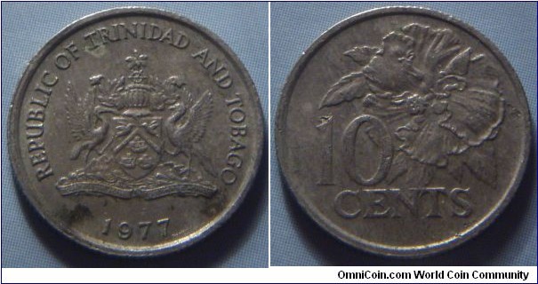 Trinidad & Tobago | 
10 Cents, 1977 | 
16.3 mm, 1.4gr. | 
Copper-nickel | 

Obverse: National Coat of Arms, date below | 
Lettering: REPUBLIC OF TRINIDAD AND TOBAGO 1977 | 

Reverse: Flaming Hibiscus, denomination below| 
Lettering: 10 CENTS |