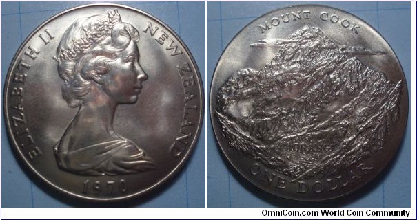 New Zealand | 
1 Dollar, 1970 | 
38.61 mm, 28.28 gr. | 
Copper-nickel | 

Obverse: Queen Elizabeth II facing right, date below | 
Lettering: ELIZABETH II NEW ZEALAND 1970 | 

Reverse: Mount Cook, denomination below | 
Lettering: MOUNT COOK AORANGI ONE DOLLAR |