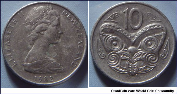 New Zealand |
10 Cents, 1982 |
23.62 mm, 5.65 gr. |
Copper-nickel |

Obverse: Queen Elizabeth II facing right, date below |
Lettering: ELIZABETH II NEW ZEALAND 1971|

Reverse: Maori Mask, denomination above |
Lettering: 10 |