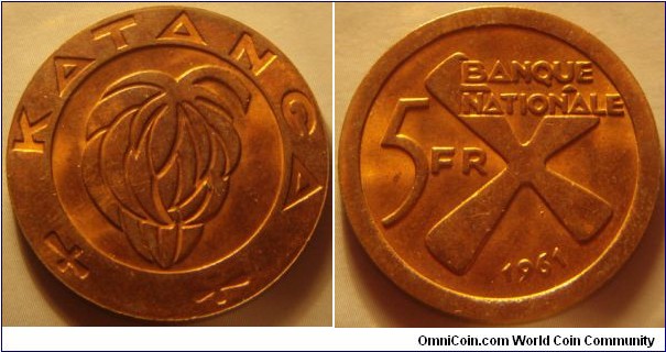 Katanga |
5 Francs, 1961 |
26 mm, 6.54 gr. |
Bronze |

Obverse: Bunch of bananas |
Lettering: KATANGA |

Reverse: Denomination left, date below. The cross symbolizes iron bars |
Lettering: BANQUE NATIONALE 5 FR 1961 |