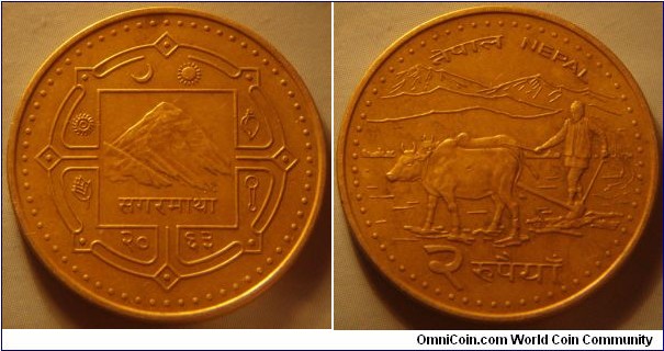 Nepal | 
2 Rupees, 2006 (2063) | 
24.93 mm, 5 gr. | 
Brass plated Steel | 

Obverse: Mount Everest in central square, date below | 
Lettering: सगरमाथा २०६३ | 

Reverse: Farmer ploughing with water buffalos, denomination below | 
Lettering: नेपाल NEPAL २ रुपैयाँ |