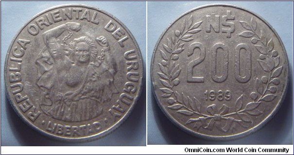 Uruguay | 
200 Nuevos Pesos, 1989 | 
26.7 mm, 10.1 gr. | 
Stainless Steel | 

Obverse: A man who breaks free from his chains | 
Lettering: • REPUBLICA ORIENTAL DEL URUGUAY • LIBERTAD | 

Reverse: Denomination within Laurel wreath, date below | 
Lettering: N$ 200 1989 |