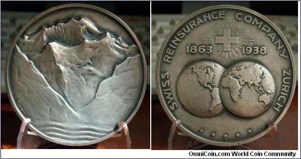 1938 Swiss Reinsurance Company Medal by Huguenin. Silver: 70MM./151.7 gm.
Obv: Scene of Swiss Mountains signed Huguenin on lower left . Rev: Legend SWISS REINSURANCE COMPANY ZURICH around. Swiss Cross in Middle separate 1863  1938 on each side. Global map in lower centre. 5 Stars at bottom with hallmarks. Signed Huguenin at right. 
