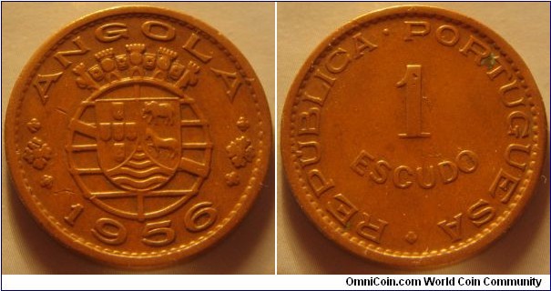 Angola | 
1 Escudo, 1956| 
26 mm, 7.9 gr. | 
Bronze | 

Obverse: National Coat of Arms, date below | 
Lettering: ANGOLA 1956 |

Reverse: Denomination | 
Lettering: REPUBLICA • PORTÚGUESA 1 ESCUDOS |