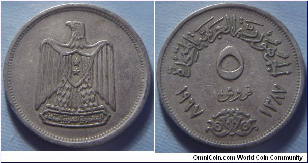 Egypt | 
5 Piastres, 1967 (1387) | 
25 mm, 4.5 gr. | 
Copper-nickel | 

Obverse: National Coat of Arms | 

Reverse: Denomination, Gregorian date left, Arabic date right | 
Lettering: الجمهورية العربية المتحدة ٥ قروش ١٩٧٢ ١٣٨٧ |