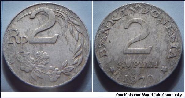 Indonesia | 
2 Rupiah, 1970 | 
26 mm, 2.3 gr. | 
Aluminium | 

Obverse: Rice and cotton stalks, denomination above | 
Lettering: Rp 2 |  

Reverse: Denomination, date below | 
Lettering: * BANK INDONESIA * 2 RUPIAH 1970 |