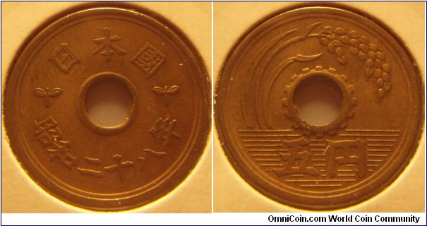Japan | 
5 Yen, 1953 | 
22 mm, 3.75 gr. | 
Brass | 

Obverse: Date below centre hole | 
Lettering: 日本国 昭和二十八年 | 

Reverse: Ear of rice, denomination below | 
Lettering: 五円 |