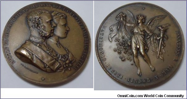 1881 Austria Prince Rudolf & Princess Stephanie of Belgium Marrige Medal by J. Tautenhayn. Bronze: 55MM.
Obv: Conjoined busts of Crown Prince Rudolf in uniform, with Sash & Badge of the Golden Fleece with Princee Stephanie of Belgium. Rev: Angel pouring Flowers & holding a Touch. Star above. Legend MATRIMONIO.IVNGTI.VINDOB.X.MAII.MDCCCLXXXI. 
