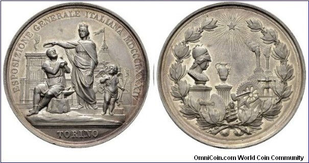1884 Italy Turin The Italian General Exhibition in Turin Medal by Bianchi and Speranza. Silver: 53.26 gms.
Obv: Patron goddess crowned a worker sitting on an anvil behind exhibition building. Rev: Bust of Pallas Athena in front of unit shaft of art and industry.
