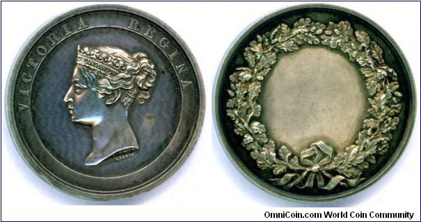 1840 UK Reign of Queen Vcitoria Vigina (1837-1901) House of Hanover Medal. Silver: 45MM./56 gms.
Obv: Within circle relief Portrait Bust of Queen Victoria crowned with diadem left. Legend VICTORIA REGINA. Signed W.J.TAYLOR. Rev: Oak wreath with Acorns boed & knotted. Blank center.
