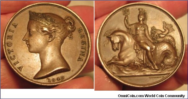 1848 UK Queen Victoria Naval General Services Medal. Bronze: 36MM.
Obv: Crown bust of Queen Victoria to left. Legend VICTORIA REGENA, 1848. Signed W.WYON R.A. Rev: Britannia with Trident, seated sideways on a Seahorse. Signed W. WYON R.A.
