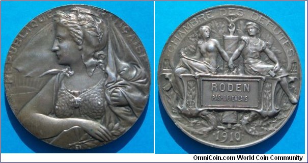 1910 France Chambre Des Deputes Medal by Daussin. Silver: 60 gms.
Obv: Franch beauty wearing scarf to left & holding laurel. Sun Rays background. Legend  REPUBLIQUE FRANCAISE Signed Daussin. Rev: Two Females representing CDD join hands & seats on banner RODEN PAS-DES-CALAIS.  Fasces in center with finger pointing at top. Legend CHAMBRE DES DEPUTES 1910.
