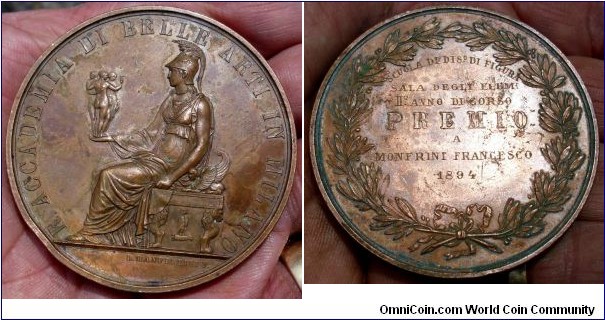 1894 Italy Academy Fine Arts Milan Medal by Manfredini. Bronze: 65MM./97.5 gms.
Obv: Seated Minerva left holding statues of 3 Graces. Legend ACCADAMIA DI BELLE ARTI IN MILANO. Exergue signed L. MANFRELINI F.  Rev: Laurel Wreath with love knot. Legend PREMIO with awarded details dated 1894
