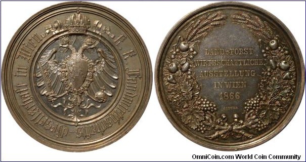 1866 Austria Vienna Exhibition Medal by Jauner. Silver: 57MM./87.2 gms.
Obv.: Coat of Arm of Empire with Crown on top.Legend surround.  Rev.:  Wreath of Wheat, frouts & leaves with love knot surround. Legend LAND u. FROST WIRTHSCHAFTLICHE AUSSTELLUNG IN WIEN 1866. Signed JAUNER