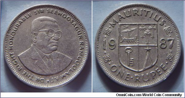 Mauritius | 
1 Rupee, 1987 | 
26.5 mm, 7.45 gr. | 
Copper-nickel | 

Obverse: Sir Seewoosagur Ramgoolam facing right | 
Lettering: * DR THE RIGHT HONOURABLE SIR SEEWOOSAGUR RAMGOOLAM KT | 

Reverse: National Coat of Arms diveides date, denmination below | 
Lettering: •MAURITIUS• •ONE•RUPEE• 1987 |