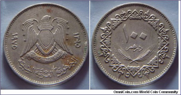 Libya Arab Republic | 
100 Dirham, 1975 (1395) | 
27 mm, 8.1 gr. | 
Copper-nickel | 

Obverse: National Coat of Arms, date to the right and left | 
Lettering: ١٩٧٥ ١٣٩٥ الجمهورية العربية الليبية | 

Reverse: Denomination | 
Lettering: ١٠٠ درهم |