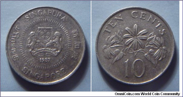 Singapore | 
10 Cent, 1987 | 
18.5 mm, 2.6 gr. | 
Copper-nickel | 

Obverse: National Coat of Arms with ribbons upwards, date below | 
Lettering: சிங்கப்பூர் SINGAPURA 新加坡 SINGAPORE 1987 | 

Reverse: The Star Jasmine, denomination below | 
Lettering: TEN CENTS 10 | 