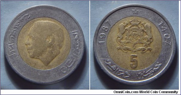 Morocco | 
5 Dirhams, 1987 (1407) | 
26.2 mm, 6.8 gr. | 
Bi-metallic: Aluminium-bronze centre in Stainless Steel ring | 

Obverse: King Hassan II facing left | 
Lettering: المملكة المغربية الحسن الثاني |

Reverse: National Coat of Arms, date left and right, denomination below | 
Lettering: 1987 1407 5 خمسة دراهم | 