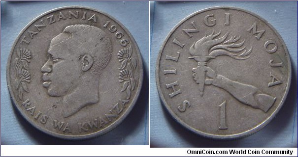 Tanzania | 
1 Shilling, 1966 | 
27.65 mm, 8 gr. | 
Copper-nickel | 

Obverse: The first president of Tanzania, Julius Nyerere, facing left flanked by flowers, date above | 
Lettering: TANZANIA 1966 RAIS WA KWANZA | 

Reverse: Hand holding a torch, denomination below | 
Lettering: SHILINGI MOJA 1 |