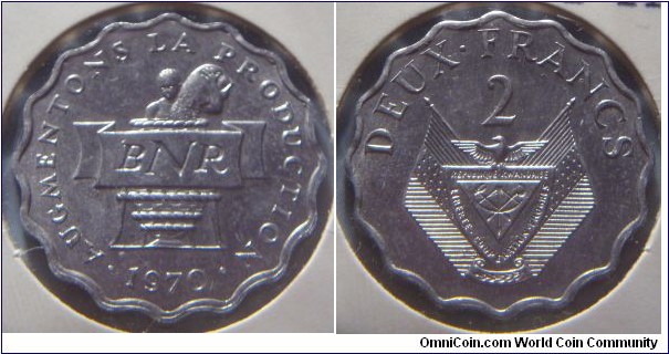 Rwanda | 
2 Francs, 1970 – FAO | 
23.5 mm, 1.51 gr. | 
Aluminum | 

Obverse: National Bank of Rwanda logo, date below | 
Lettering: • AUGMENTONS LA PRODUCTION • 1970 | 

Reverse: National Coat of Arms, denomination above | 
Lettering: DEUX • FRANCS 2 |