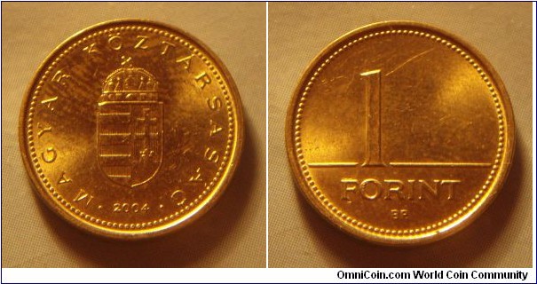 Hungary | 
1 Forint, 2004 | 
16.3 mm, 2.05 gr. | 
Nickel-brass | 

Obverse: National Coat of Arms, date below | 
Lettering: • MAGYAR KÖZTÁRSASÁG • 2004 | 

Reverse: Denomination | 
Lettering: 1 FORINT |