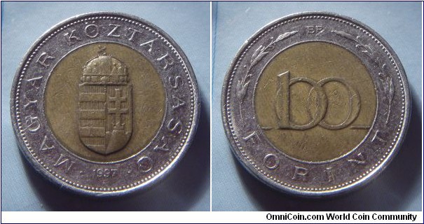 Hungary | 
100 Forint, 1997 | 
23.8 mm, 8 gr. | 
Bi-metallic: Brass plated Steel centre in Stainless Steel ring | 

Obverse: National Coat of Arms, date below | 
Lettering: • MAGYAR KÖZTÁRSASÁG • 1997 | 

Reverse: Denomination | 
Lettering: 100 FORINT |