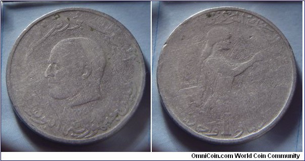 Tunisia | 
1 Dinar, 1976 | 
27.95 mm, 9.75 gr. | 
Copper-nickel | 

Obverse: Habib Bourguiba facing left, date below | 
Lettering: الجمهرية التونسية 1976 حبيب بورقيبة |

Reverse: Woman facing right amidst vegetation, denomination below | 
Lettering: البنك المركزي التونسية دينار 1 واحد  |