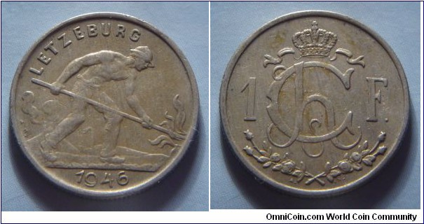 Luxembourg | 
1 Franc, 1946 | 
23 mm, 5 gr. | 
Copper-nickel | 

Obverse: Man shoveling coal, date belown | 
Lettering: LETZEBURG 1946 |

Reverse: Crowned Charlotte Monogram divides denomination | 
Lettering: Ch 1F. |