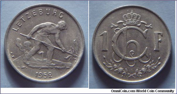 Luxembourg | 
1 Franc, 1952 | 
21 mm, 4 gr. | 
Copper-nickel | 

Obverse: Man shoveling coal, date belown | 
Lettering: LETZEBURG 1952 |

Reverse: Crowned Monogram of Charlotte divides denomination | 
Lettering: Ch 1F. |