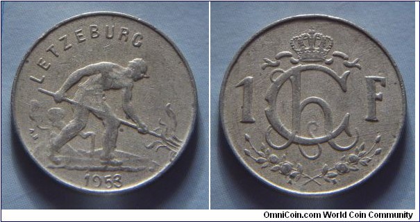 Luxembourg | 
1 Franc, 1953 | 
21 mm, 4 gr. | 
Copper-nickel | 

Obverse: Man shoveling coal, date belown | 
Lettering: LETZEBURG 1953 |

Reverse: Crowned Monogram of Charlotte divides denomination | 
Lettering: Ch 1F. |