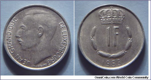 Luxembourg | 
1 Franc, 1983 | 
21 mm, 4 gr. | 
Copper-nickel | 

Obverse: Adolphe, Grand Duke of Luxembourg facing right | 
Lettering: JEAN GRAND-DUC DE LUXEMBOURG |

Reverse: Crowned  upturned horseshoe shaped of six flower buds surrounds denomination, date below | 
Lettering: 1F 1983 |