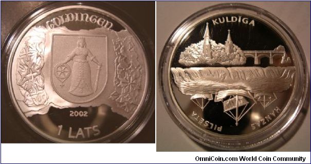 This piece is from a series of commemorative coins dedicated to cities of the Hanseatic League. It shows the city of Kuldiga and three Hanse ships; on the other side you see the city's CoA and above the old German name Goldingen.