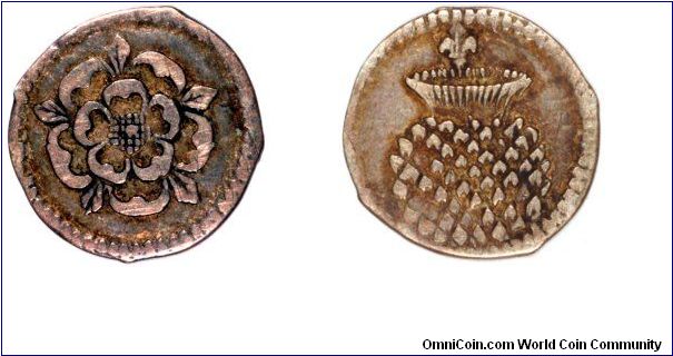 Hammered halfpenny of James I, the fleur-de-lys mintmark indicates this was issued in 1604 - 1605. Although our image makes it appear to be copper, it is in fact silver, toned somewhat. The obverse is a tudor rose, and the reverse a thistle.