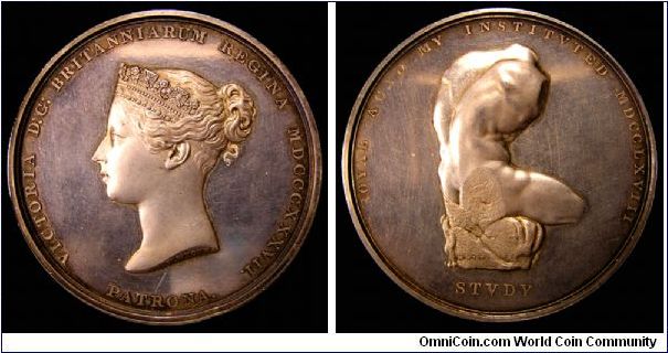 Great Britain medal, silver, about 55mm dia., about 5mm thick. Obverse: Victoria Young Head by Wyon, legend VICTORIA D:G: BRITANNIARUM REGINA MDCCCXXXVII. Under the bust is PATRONA. Reverse: sculpture of a human torso and leg. Both the bust and the sculpture include the artist's name, W WYON S on the sculpture, W.WYON R.A. on the bust. Reverse legend ROYAL ACADEMY INSTITVTED MDCCLXVII. Under the sculpture is STVDY . Edge engrvd. TO MR. A. GATLEY FOR THE BEST MODEL FROM THE LIFE. DECR. 10TH 1844.