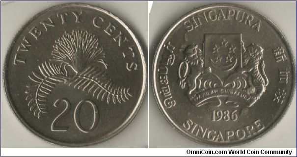 Singapore 1986 20 cents. Metal: Cupro-Nickel, 4.50g, 21.36mm. Featuring the Arms of Republic of Singapore with the year 1986 with 4 official languages around the circumference of the coins. It also features Power-Puff Plant, (no, not the power-puff girls) and goes by the scientific name Calliandra surinamensis.