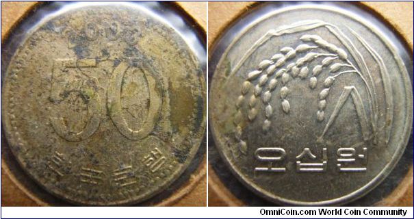S.Korea 2003 50 won. How this coin ended up having a side full of junk and the other side not, I have no idea. Grade is aUNC though if not for the junk...