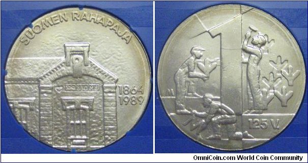 Silver token commemorating the 125th year of the Mint of Finland. This was included in a special second mint set that was issued in 1989. Obverse pictures the old mint while the reverse depicts the construction of the markka design used from 1964-1993.