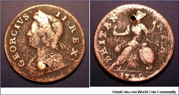George II half penny. Someone attempted a hole, but never got all the way through.