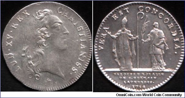 Silver jeton issued for the parish of St Germain in 1734. Bust of Louis XV obverse by Francois Marteau. Obverse also indicates that the die used was both worn and partially filled.