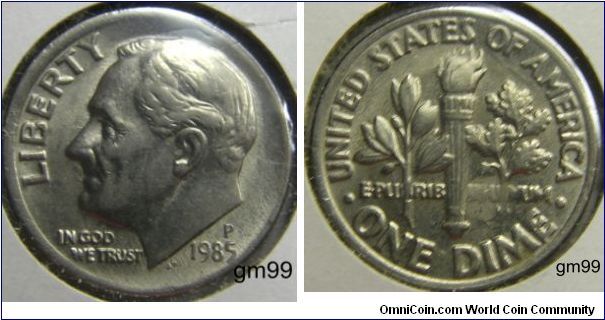 ROOSEVELT DIME 
2/3's of the dime has a Wide rim and 1/3 has no rim on Obverse side. 1985P,Mintmark: P (for Philadelphia, PA) above the date, also picked up red color on the obverse and yellow on the reverse.