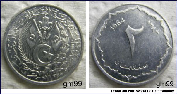 2 Centimes (Aluminum) : 1964
OBVERSE: Two flags with star and crescent on them above a third star and crescent, all within wreath,
Arabic script around central devices
REVERSE: Date in AD and AH above large 2 (arabic numeral) script below, eight-pointed border around edge,
 1964 (in western numerals) 1383 (in arabic) 2 and script