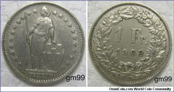 1 Franc (Copper-Nickel) : 1968-1981
Obverse; Helvetia standing holding spear and shield with cross on it,
 HELVETIA
Reverse; Value within wreath,
 1 Fr date