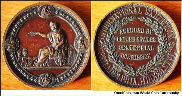 1876 PHILADELPHIA INTERNATIONAL EXHIBITION BRONZE AWARD MEDAL
AWARDED BY UNITED STATES CENTENNIAL COMMISSION IN 1876.
Text on obverse, under left foot.
Designed by: H Mitchell SC
Bronze 76 MM X 9.5 mm  285 GRAMS
