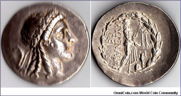 silver tetradrachm from the Aeolian city state of Myrina. Appollo laureate obverse. Statue of Apollo Gryneus standing with lustral branch and patera, omphalos and amphora at his feet