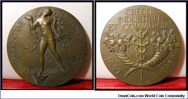 France Bank Centenary Medal by Henri Dropsy. Bronze 59 MM./100 Gm.
Obv: Naked female figure distributing coins from a cornucopia, her foot on a winged wheel. Rev: Cornucopia & caduceus.
