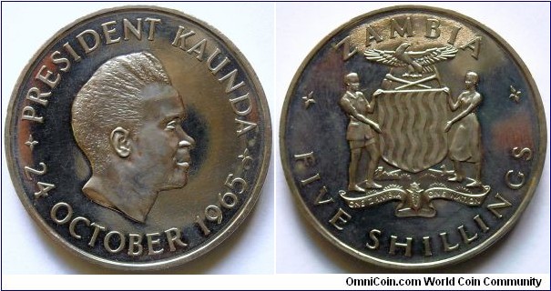5 shillings.
1965, President Kenneth Kaunda. First Anniversary of Indepencence.
Cu-ni. Weight; 28,5g.
Diameter; 39mm.
Lettering on edge; ONE ZAMBIA ONE NATION *24.10.1964*
Mintage; 10.000 units.