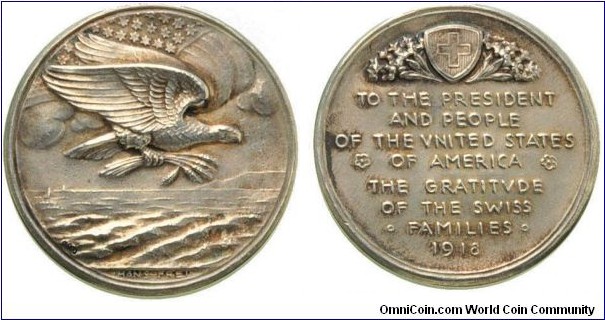 Swiss Medal by Han von Frei. Silver 39.8MM
Obv: Eagle in the clutches of ears of corn on Ocean, about U.S. flag. In the section of the medal. Rev:  To the President and all the people in the U.S.. A Greeting from the Swiss people. 
