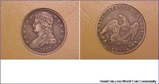 A reeded edge capped bust half dollar with the denominatin 